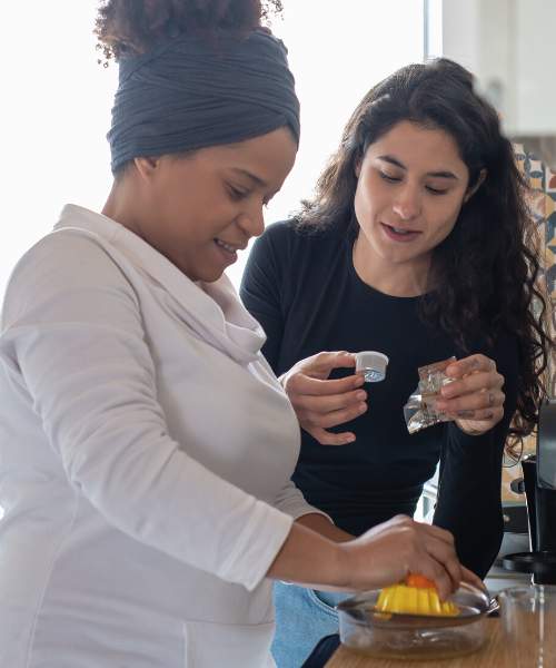 Two women enjoying preparing healthy food.